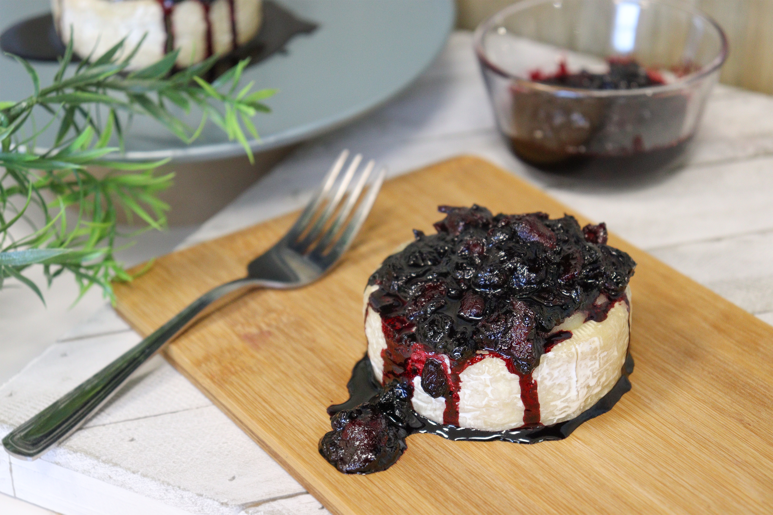 Brie cheese topped with haskap berries, bacon and vinegar